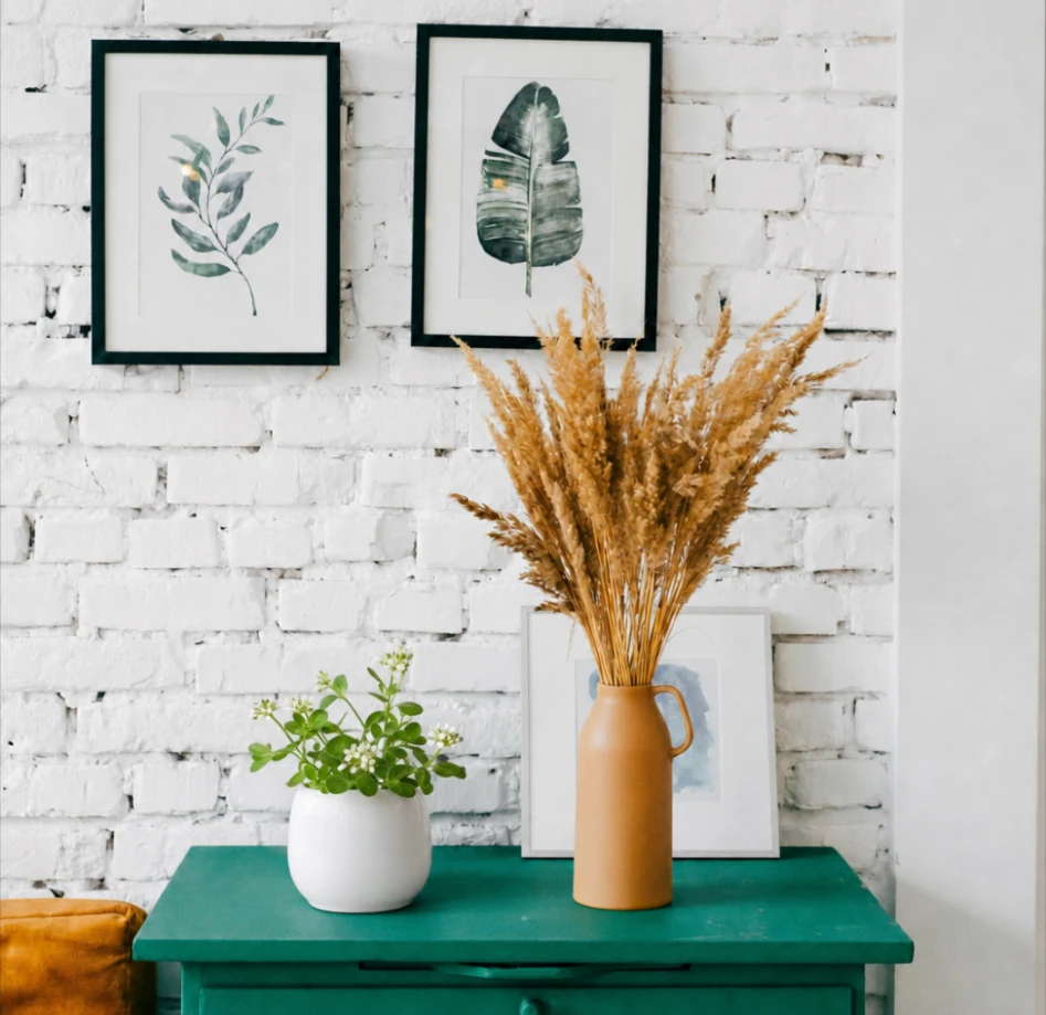 The same side table with a white pot of flowering greenery where the photo frame used to be