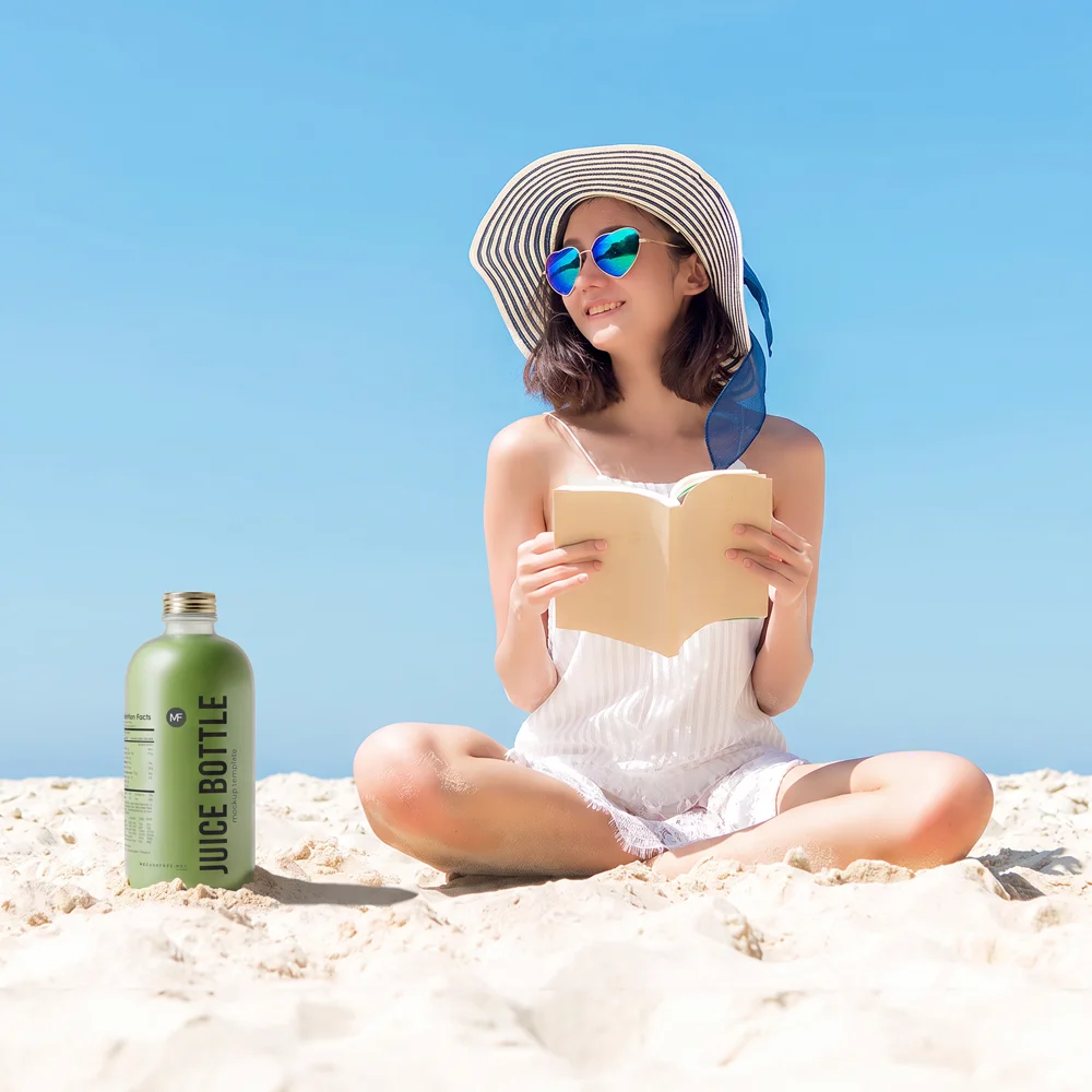 The same beach photo with the coconut drink replaced by a green juice bottle standing in the sand