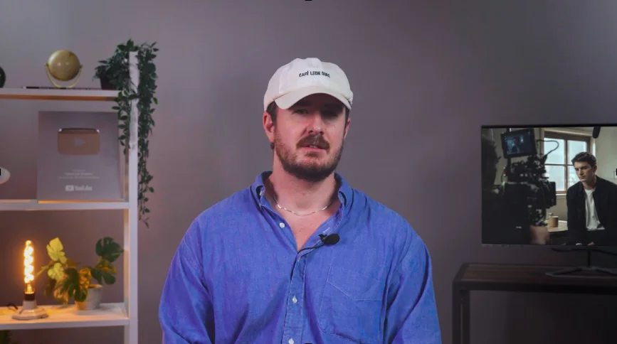 A presenter speaking to camera in a studio, with no subtitles