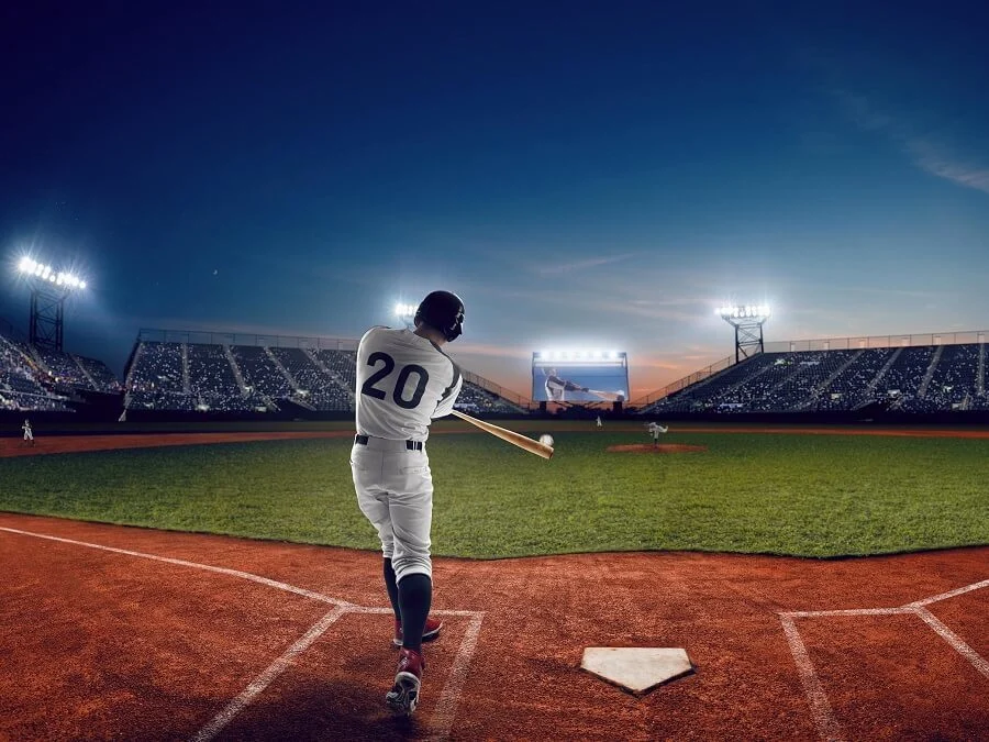 A still photo of a baseball batter mid-swing under stadium lights