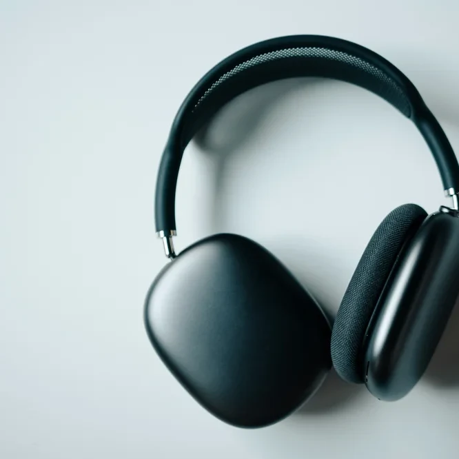 Black over-ear headphones photographed flat on a plain pale gray surface