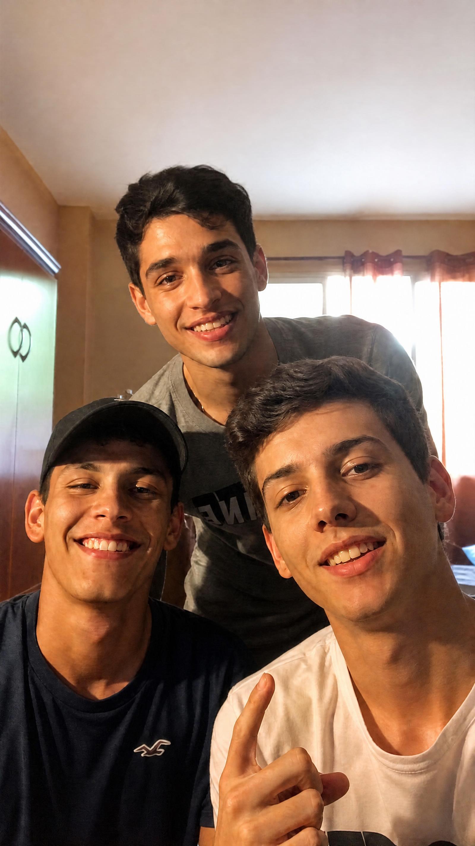Foto de tres amigos con la iluminación mejorada mediante un prompt de edición para Grok