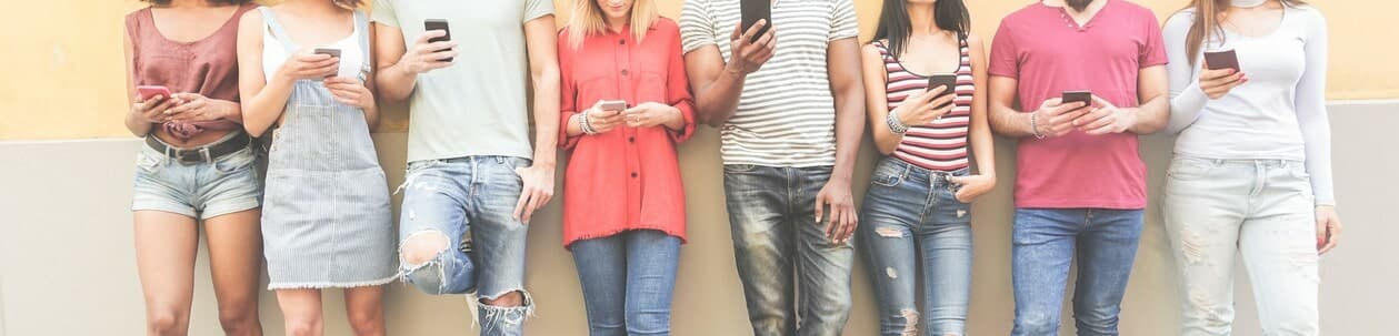 数人の男女がスマホでSNSを見ているイメージ