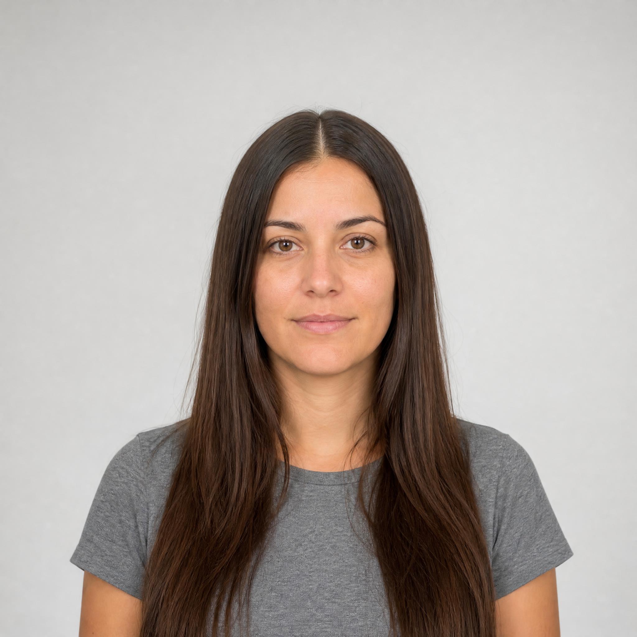 Retrato de partida de mujer con melena castaña larga y lisa sobre fondo gris claro