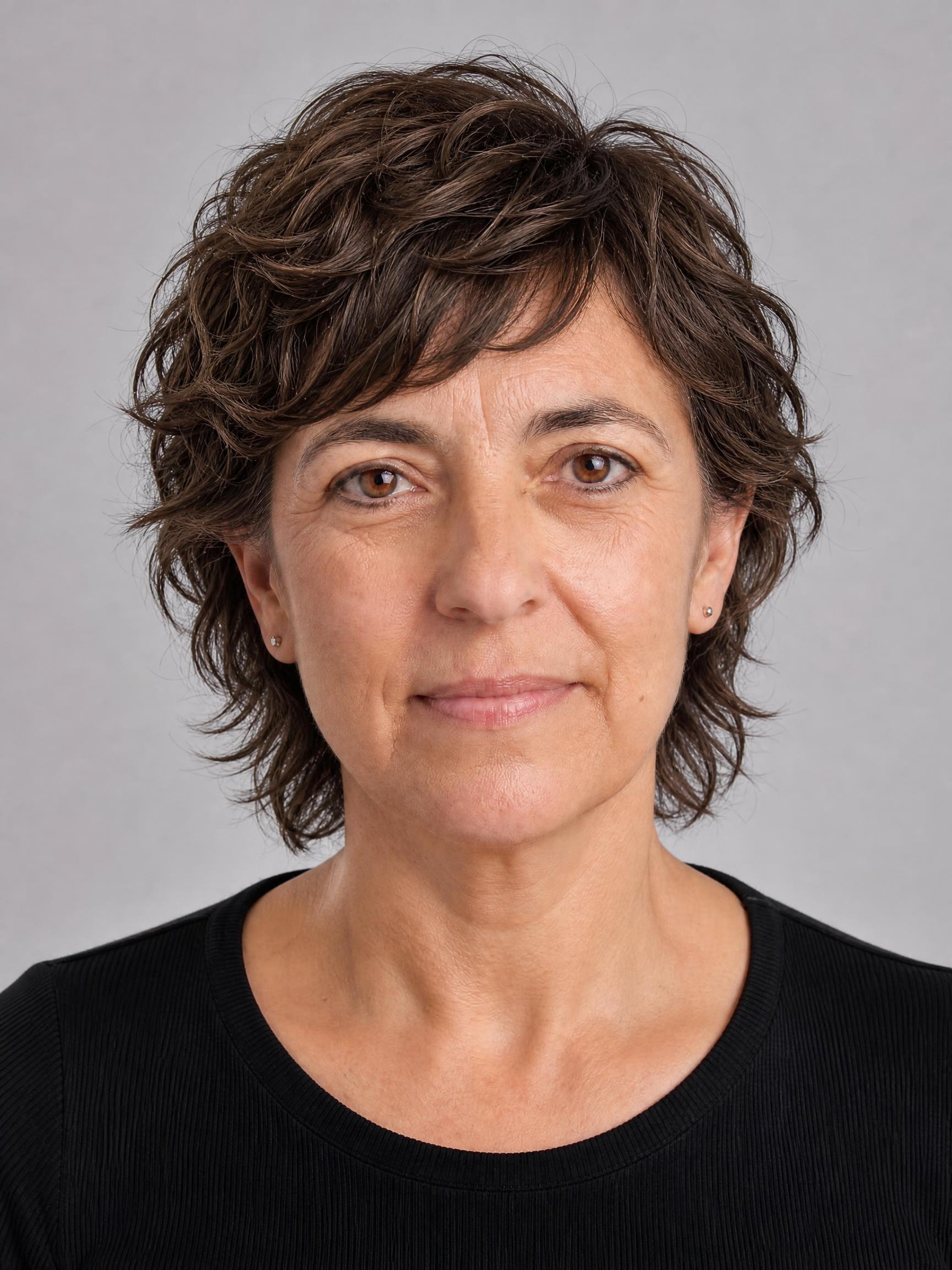 Mujer de unos 50 años con corte mixie castaño, corto por delante y ligeramente más largo en la nuca, con textura ondulada