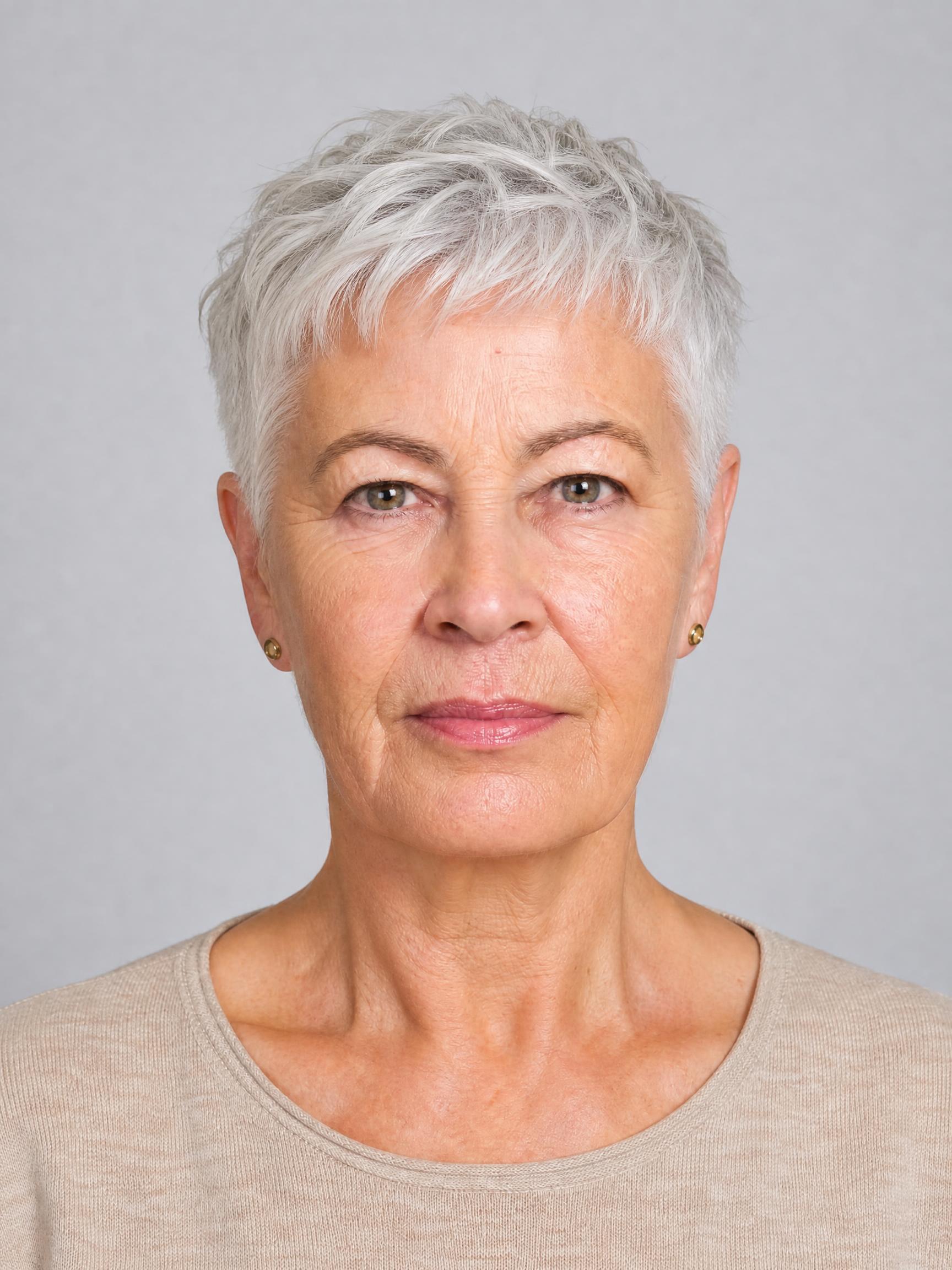 Mujer de unos 60 años con corte garçon Soft Crop Francés en cabello blanco, nuca despejada y volumen suave en la parte superior