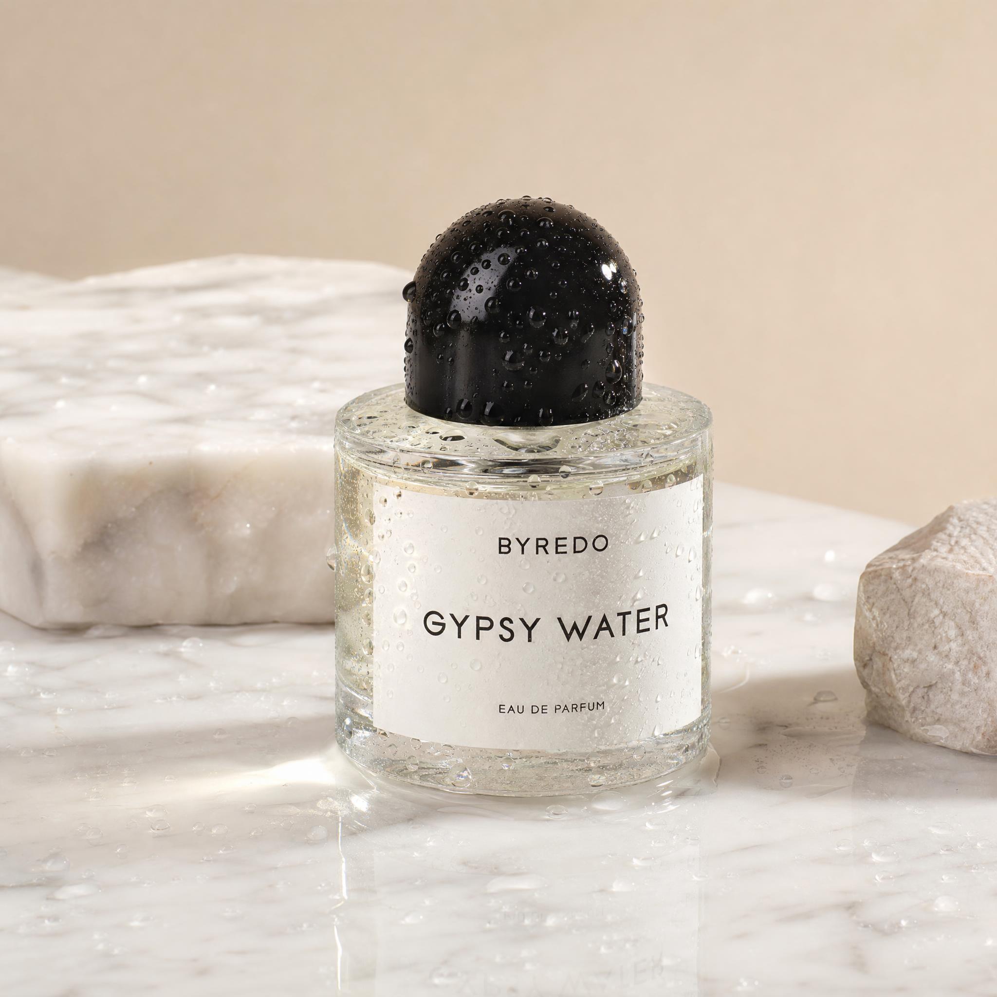 Frasco de perfume sobre mármol blanco húmedo con gotas de agua e iluminación de estudio