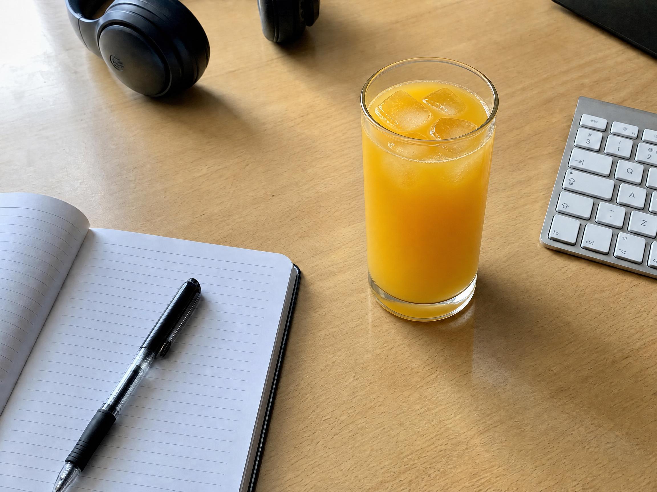 Después: el mismo escritorio con la taza sustituida por un vaso de jugo de naranja con hielo
