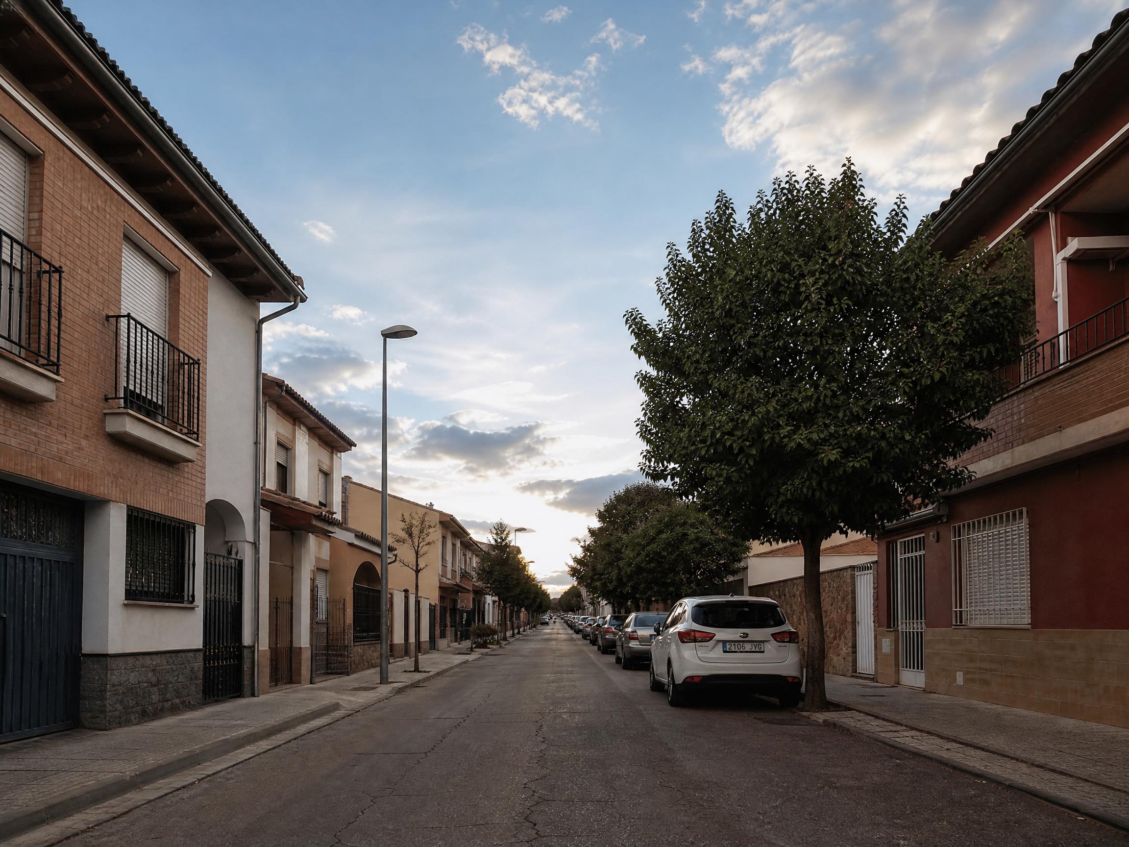 Antes: fotografía de una calle residencial con árboles y cielo parcialmente nublado