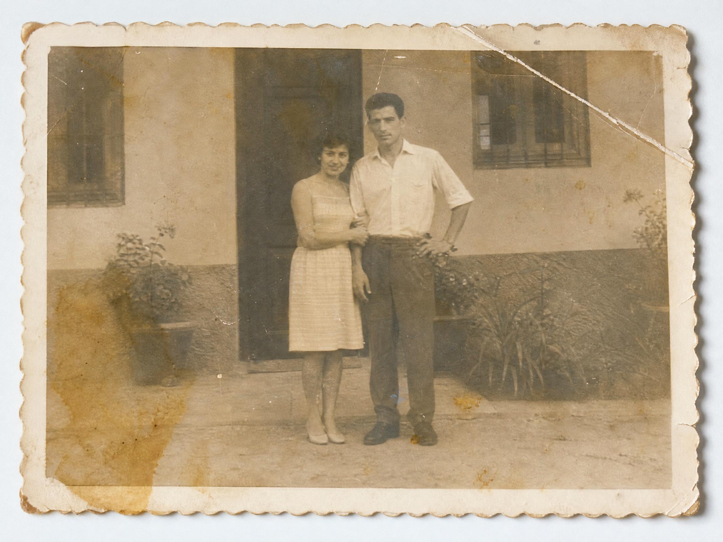 Antes: fotografía familiar antigua con manchas, un pliegue marcado y color sepia descolorido