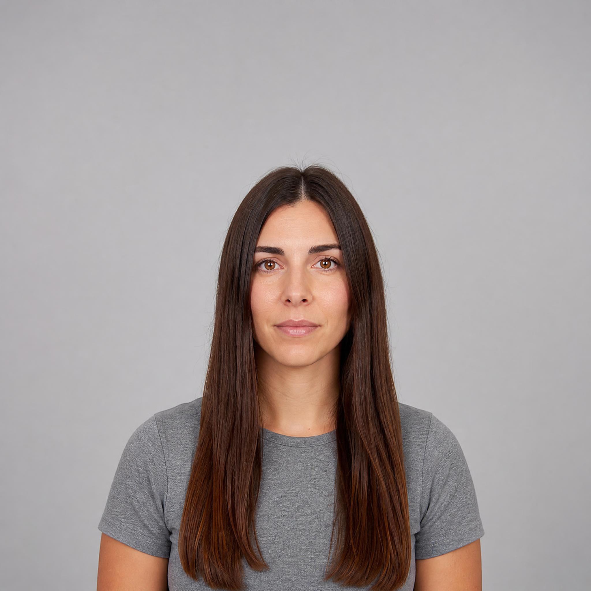 Retrato de partida femenino con melena larga y lisa castaña sobre fondo gris claro
