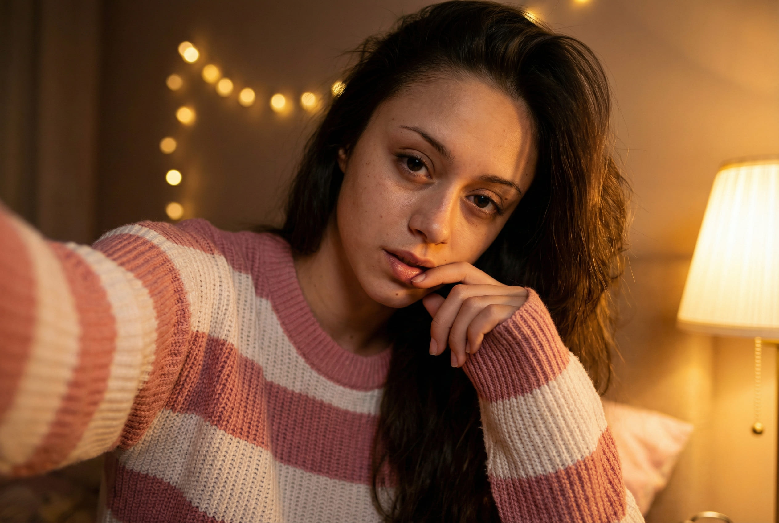 Cozy low-light bedroom selfie with warm lighting