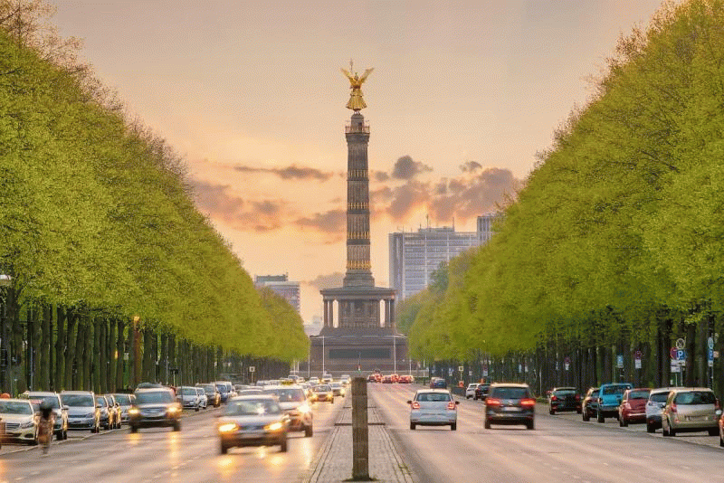Ein animiertes Vorher-Nachher-GIF der Berliner Siegessäule: Die vielbefahrene Straße voller Autos im Vordergrund leert sich im Loop wie von Zauberhand und hinterlässt eine komplett freie Fahrbahn dank KI-Retusche.