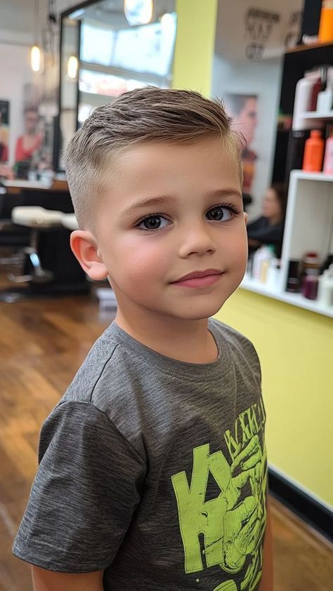 Ein kleiner Junge mit einem klassischen, sauber geschnittenen Fade Cut, bei dem die Seiten einen sanften Übergang zeigen und das kurze Deckhaar ordentlich zur Seite gestylt ist.