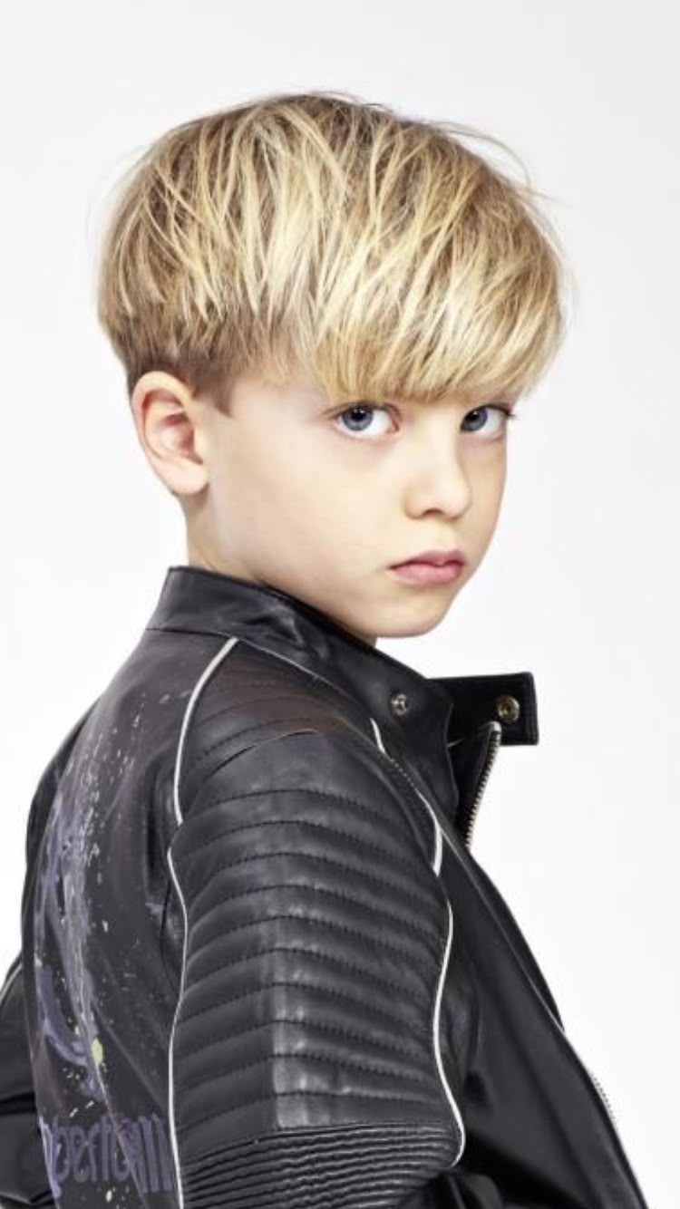 Ein Junge mit hellem, glatten Haar und einem kurzen Bob, bei dem das Haar mit gleichmäßiger Länge knapp über den Ohren und als gerader Pony geschnitten ist.