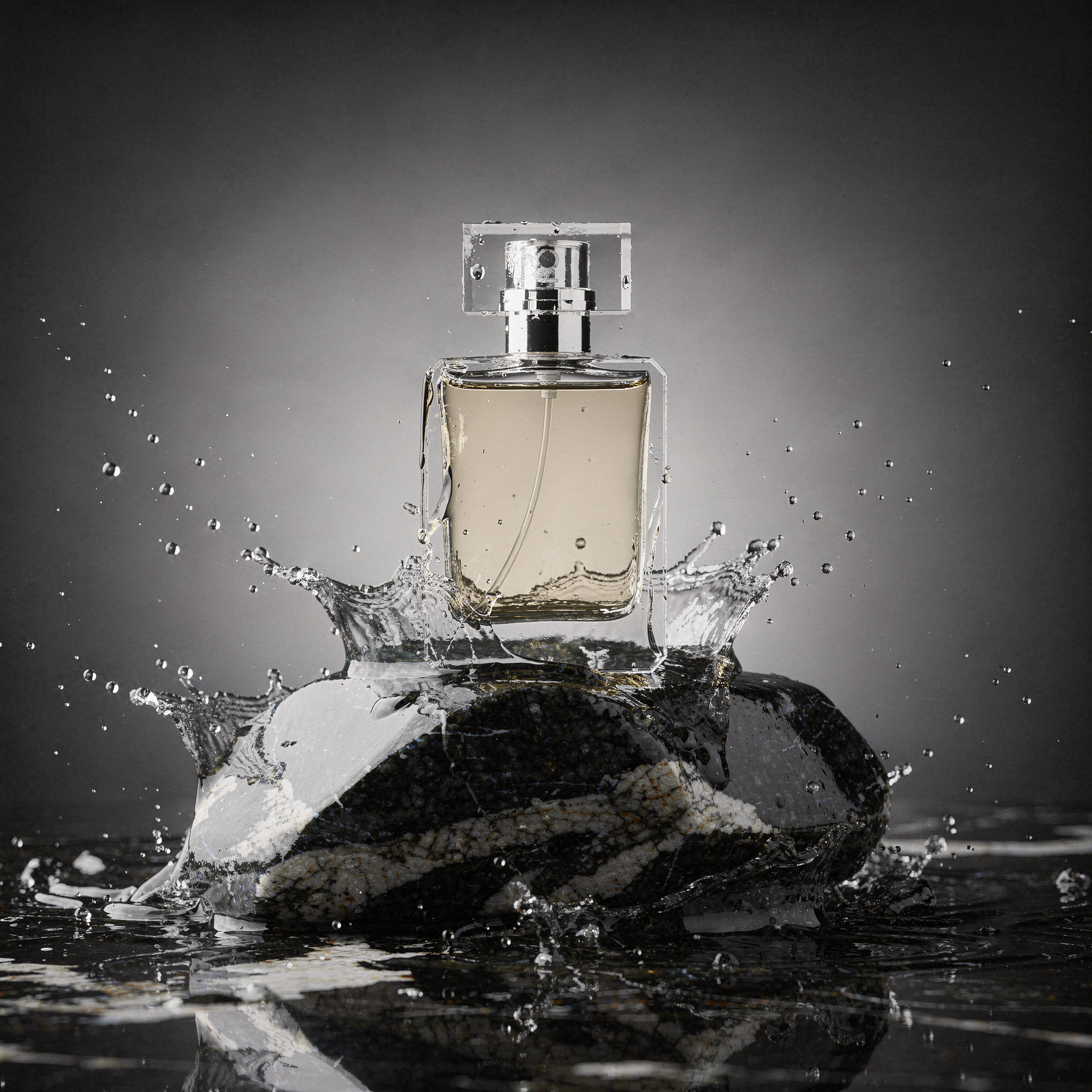 Botella de perfume de cristal sobre roca de granito negro con salpicaduras de agua generada con FLUX.2 Pro