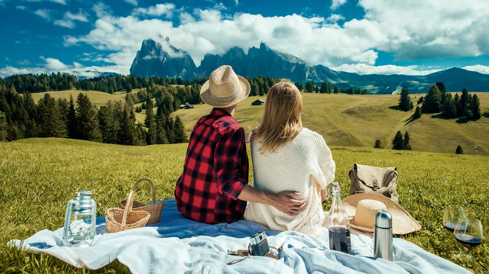 The same picnic photo with a deeper blue sky, brighter clouds, and golden grass
