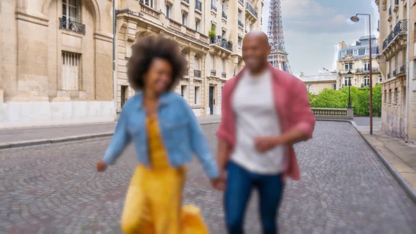 The same photo with the buildings and tower sharp and the couple in front blurred