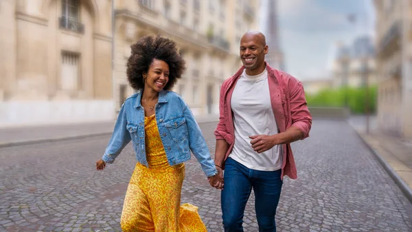 The same photo with the couple sharp and the street, buildings, and tower behind them blurred