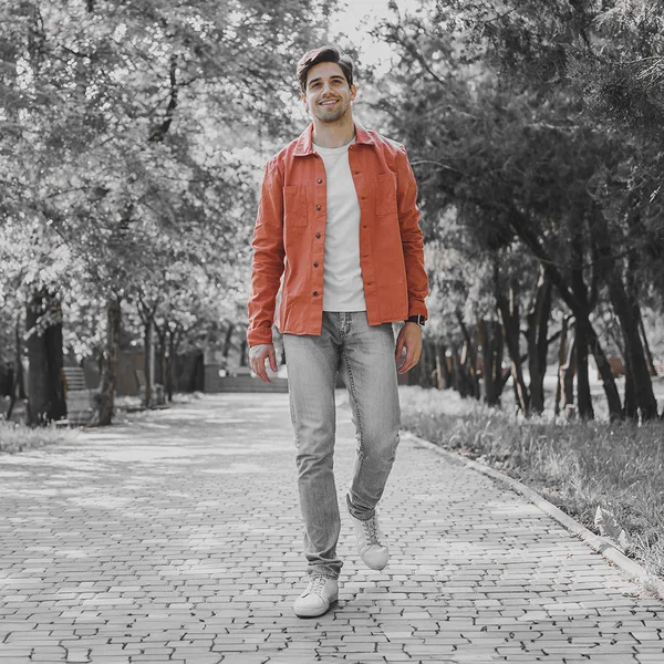 The park photo in black and white except for the orange jacket