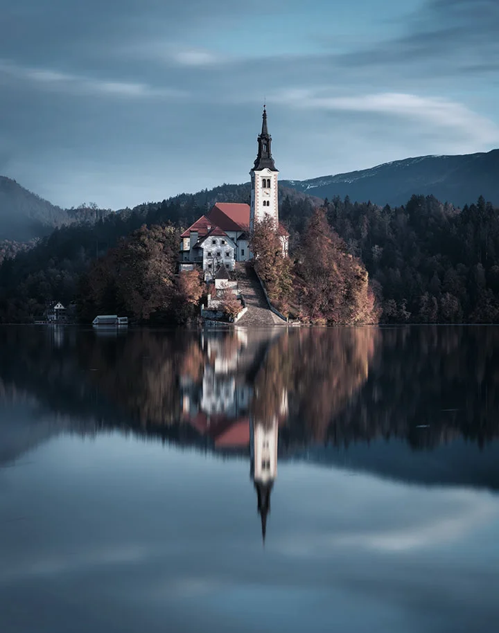 The same lake scene in cool blue tones, with the autumn trees turned a muted brown